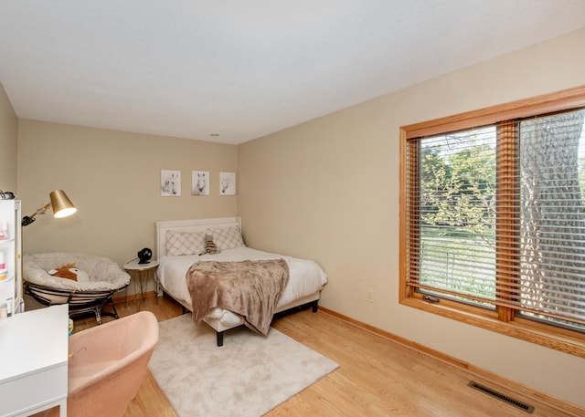 bedroom featuring light wood-style floors and baseboards