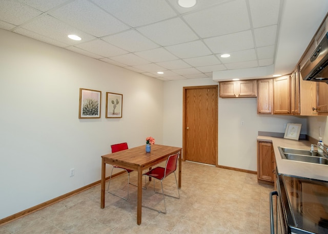 dining space featuring a paneled ceiling, recessed lighting, and baseboards