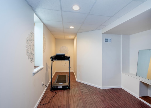 exercise area with recessed lighting, wood finished floors, a drop ceiling, and baseboards