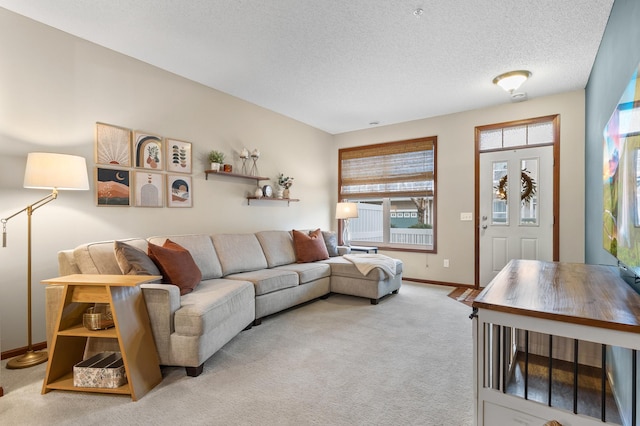 carpeted living area featuring baseboards and a textured ceiling