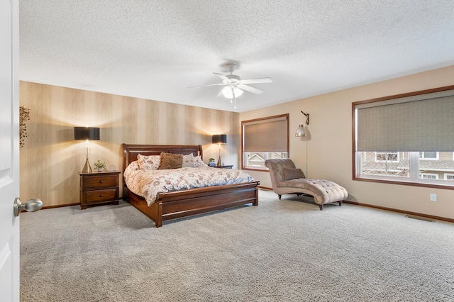 bedroom with baseboards, carpet flooring, a textured ceiling, and visible vents