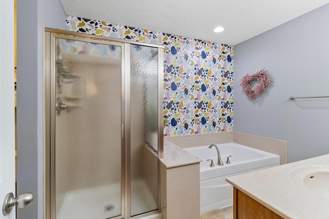 full bath with a garden tub, vanity, wallpapered walls, a textured ceiling, and a stall shower