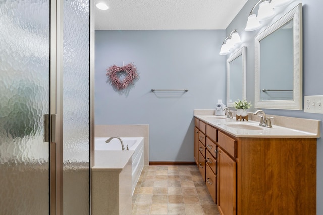 full bath with double vanity, a shower stall, a sink, and a garden tub