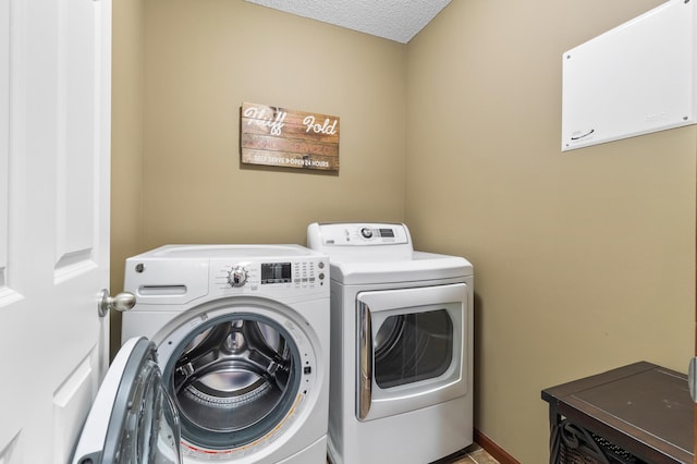 laundry room with separate washer and dryer, laundry area, and a textured ceiling