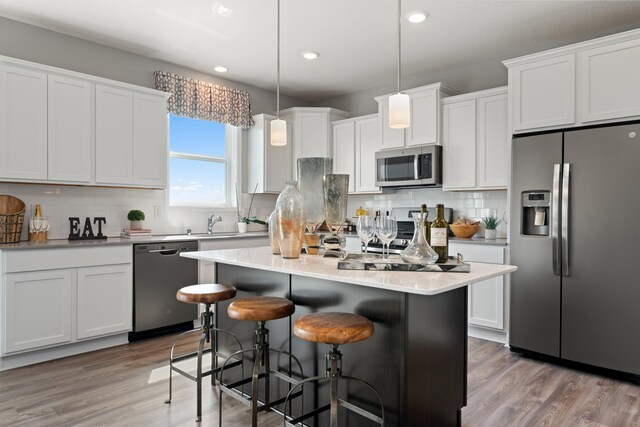 1064 Aster Blvd, Rosemount, MN 55068 - kitchen featuring stainless steel appliances, a breakfast bar, decorative backsplash, recessed lighting, and white cabinetry