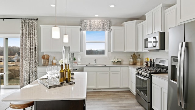 1064 Aster Blvd, Rosemount, MN 55068 - kitchen with appliances with stainless steel finishes, a sink, white cabinetry, decorative backsplash, and a center island