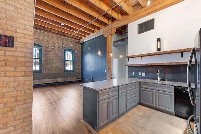 kitchen featuring gray cabinetry, wooden ceiling, beam ceiling, a sink, and brick wall