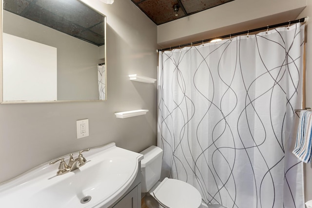 bathroom with toilet, vanity, and curtained shower