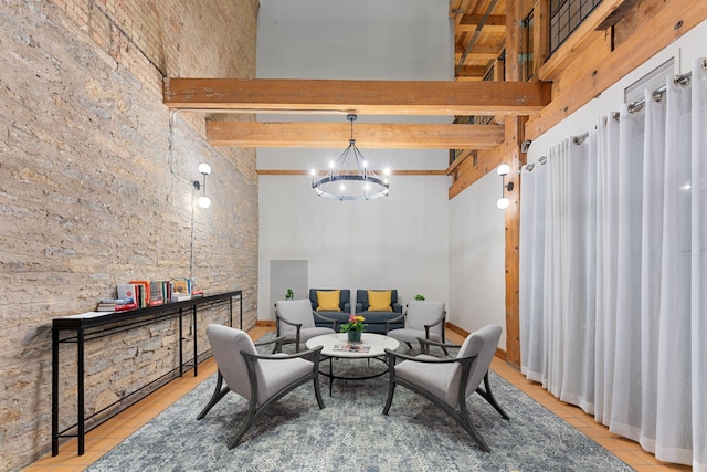 living area with tile patterned flooring, a chandelier, a high ceiling, and beam ceiling