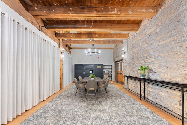dining space with light tile patterned floors, beam ceiling, and wooden ceiling