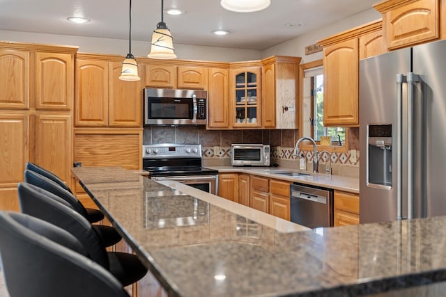 2606 Hulett Ct, Faribault, MN 55021 - kitchen with stainless steel appliances, a sink, a kitchen breakfast bar, glass insert cabinets, and backsplash