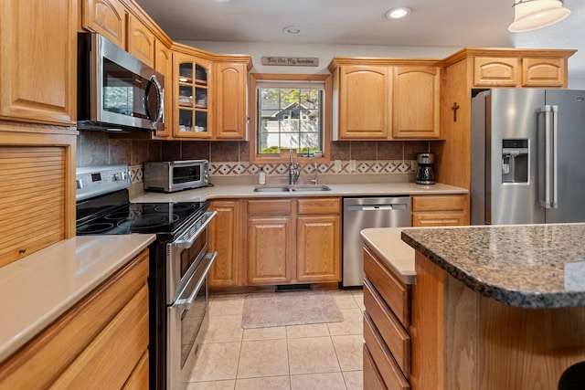 2606 Hulett Ct, Faribault, MN 55021 - kitchen featuring appliances with stainless steel finishes, a sink, tasteful backsplash, recessed lighting, and glass insert cabinets