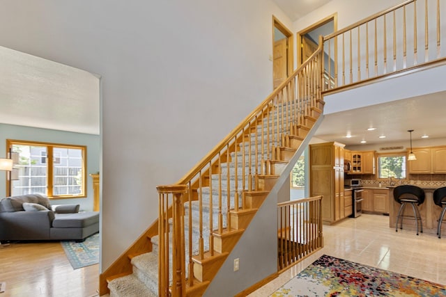 2606 Hulett Ct, Faribault, MN 55021 - staircase featuring a towering ceiling and recessed lighting
