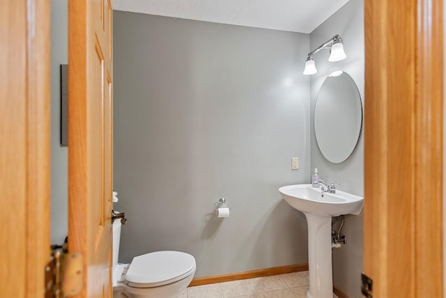 2606 Hulett Ct, Faribault, MN 55021 - bathroom with toilet, tile patterned flooring, baseboards, and a sink