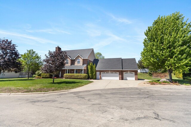 2606 Hulett Ct, Faribault, MN 55021 - traditional home featuring concrete driveway, a garage, a front yard, a chimney, and a shingled roof