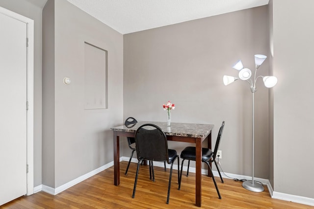 dining area featuring baseboards and wood finished floors