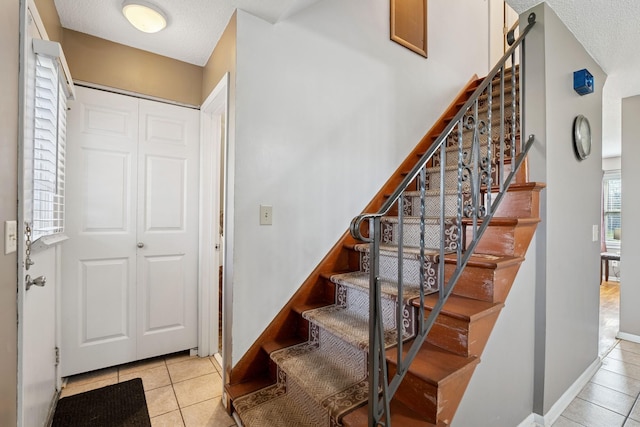stairs featuring baseboards and tile patterned flooring