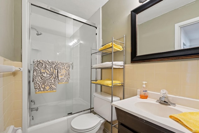 full bathroom featuring vanity, toilet, tile walls, tasteful backsplash, and combined bath / shower with glass door