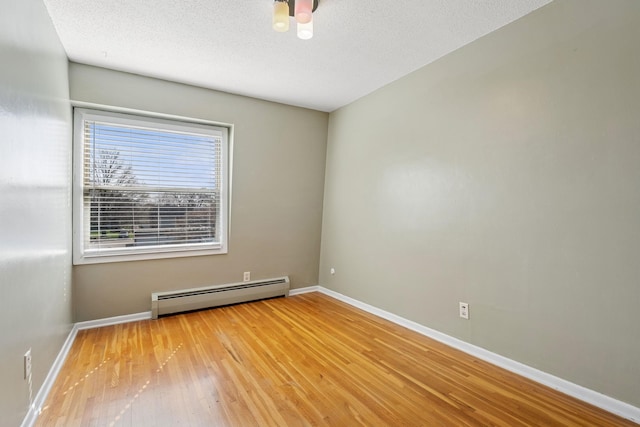 unfurnished room with ceiling fan, wood-type flooring, a textured ceiling, baseboards, and a baseboard heating unit