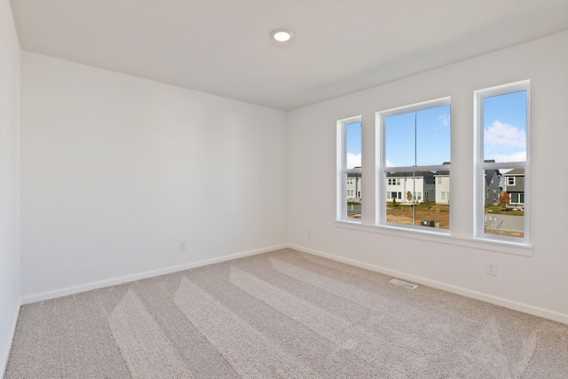 carpeted empty room with baseboards and recessed lighting