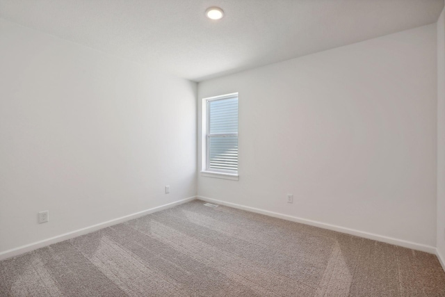 unfurnished room with carpet flooring and baseboards