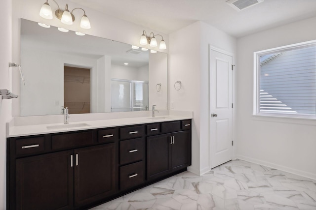 bathroom featuring a stall shower, double vanity, marble look tile flooring, a walk in closet, and baseboards