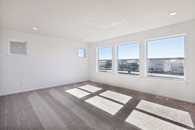 carpeted spare room featuring baseboards and recessed lighting
