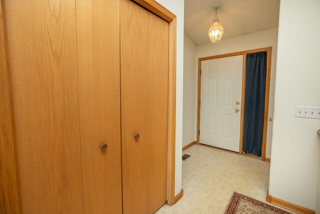 hallway featuring baseboards and light floors