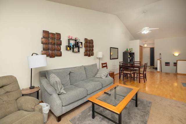 living area with carpet floors, a ceiling fan, wood finished floors, and high vaulted ceiling