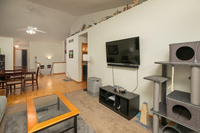 living room featuring vaulted ceiling, a ceiling fan, wood finished floors, and visible vents