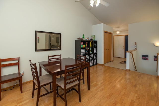 dining space featuring a ceiling fan, light wood-style flooring, and high vaulted ceiling
