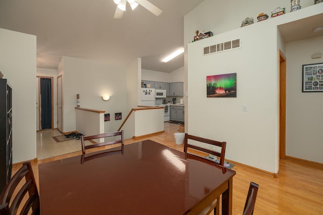 dining area with a ceiling fan, baseboards, visible vents, and light wood-type flooring