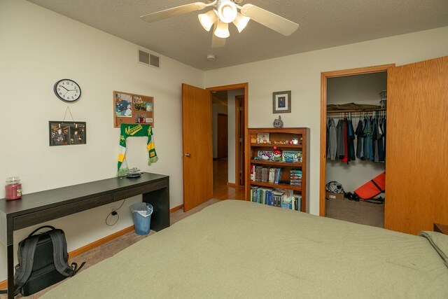 bedroom with ceiling fan, visible vents, carpet, and a closet