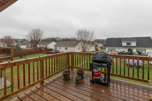 wooden deck featuring a residential view and a lawn