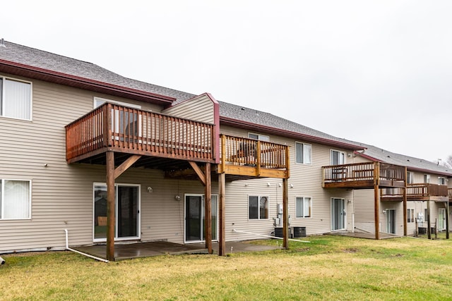 rear view of property with a lawn, a patio, central AC unit, and a wooden deck
