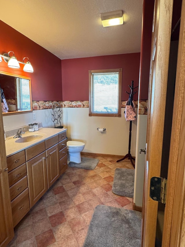 79317 355th St, Clinton, MN 56225 - bathroom with toilet, vanity, a textured ceiling, and a wainscoted wall
