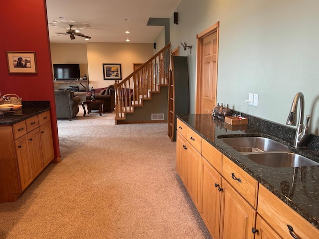 79317 355th St, Clinton, MN 56225 - kitchen with a sink, light colored carpet, a ceiling fan, open floor plan, and dark stone counters