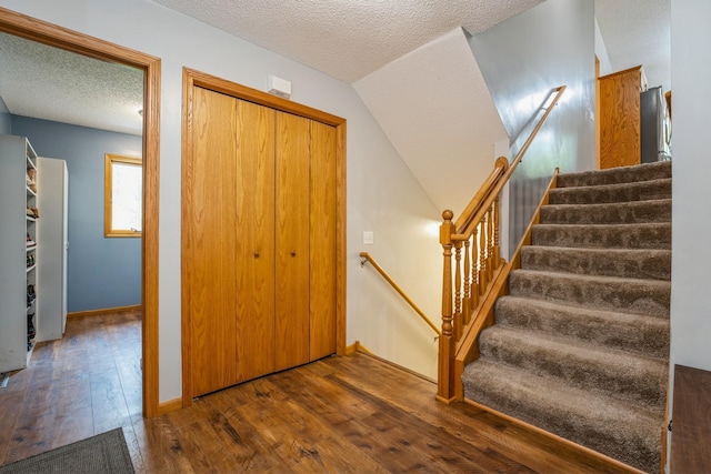 2686 56th Ave, Princeton, MN 55371 - staircase with hardwood / wood-style floors, a textured ceiling, and baseboards