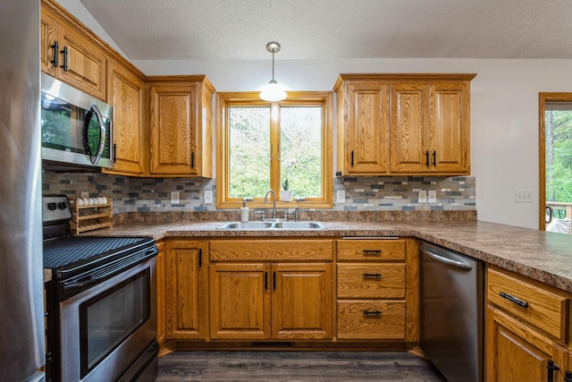 2686 56th Ave, Princeton, MN 55371 - kitchen featuring appliances with stainless steel finishes, a sink, brown cabinetry, tasteful backsplash, and dark wood finished floors