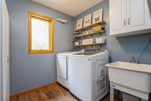 2686 56th Ave, Princeton, MN 55371 - laundry room with cabinet space, independent washer and dryer, wood finished floors, a textured ceiling, and baseboards