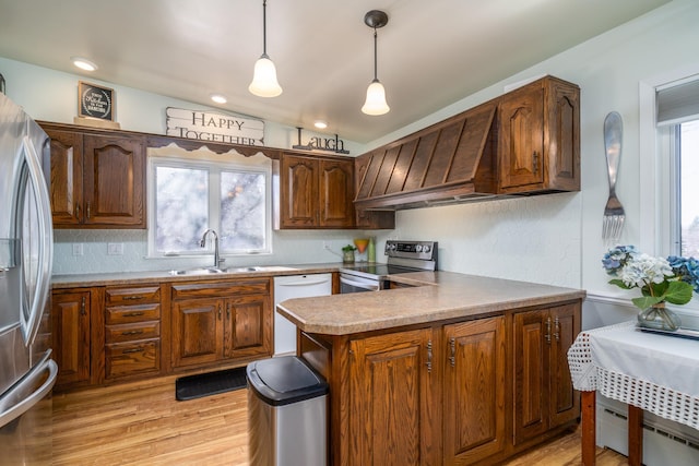 118 Golf Ter, Crookston, MN 56716 - kitchen with decorative light fixtures, appliances with stainless steel finishes, a sink, a baseboard heating unit, and light wood-style floors