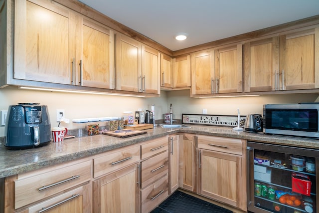 118 Golf Ter, Crookston, MN 56716 - kitchen with stainless steel microwave, light brown cabinetry, wine cooler, and light stone countertops