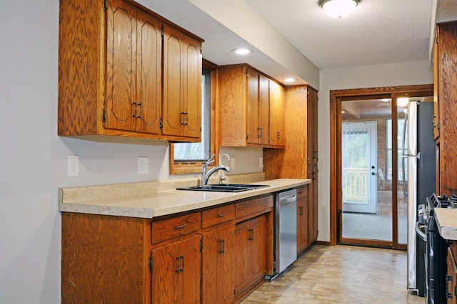 kitchen with a sink, brown cabinets, and stainless steel appliances