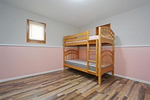 bedroom featuring baseboards and wood finished floors