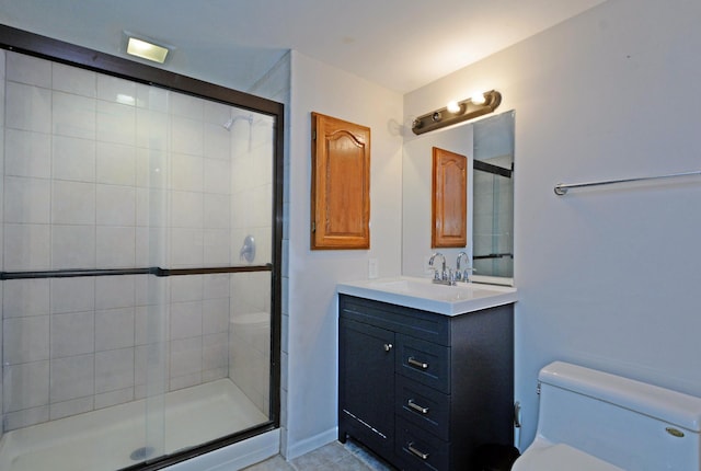 bathroom featuring vanity, tile patterned floors, a stall shower, and toilet