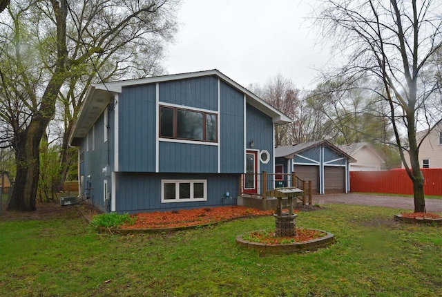 view of front of home featuring fence, a front lawn, driveway, and a garage
