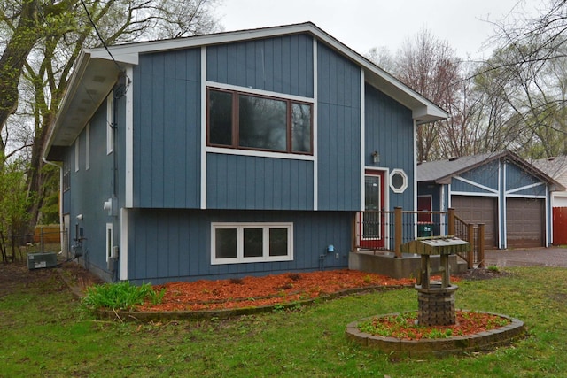 view of front facade with an attached garage, a front yard, and aphalt driveway