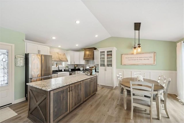 23892 187th St NW, Big Lake, MN 55309 - kitchen featuring freestanding refrigerator, vaulted ceiling, a center island, white cabinets, and light wood finished floors