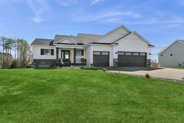 23892 187th St NW, Big Lake, MN 55309 - modern farmhouse featuring an attached garage, concrete driveway, a front lawn, stone siding, and covered porch