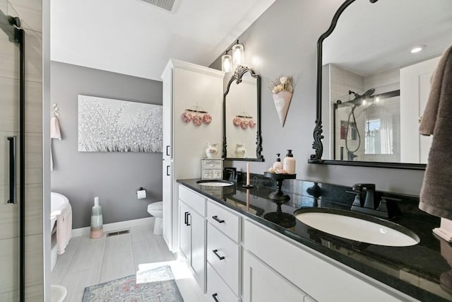 23892 187th St NW, Big Lake, MN 55309 - bathroom with a stall shower, toilet, double vanity, tile patterned floors, and baseboards